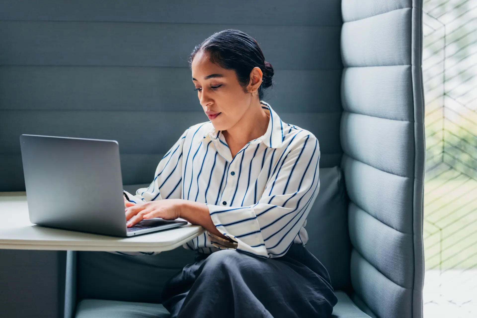 Person working on a laptop in a quiet office booth